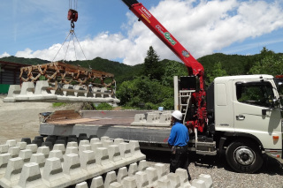 製品をクレーン付きトラックで運送